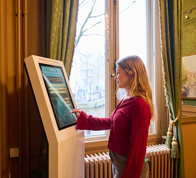 Stijlkamer met kristallen kroonluchter en wandbekleding in het Grachtenmuseum